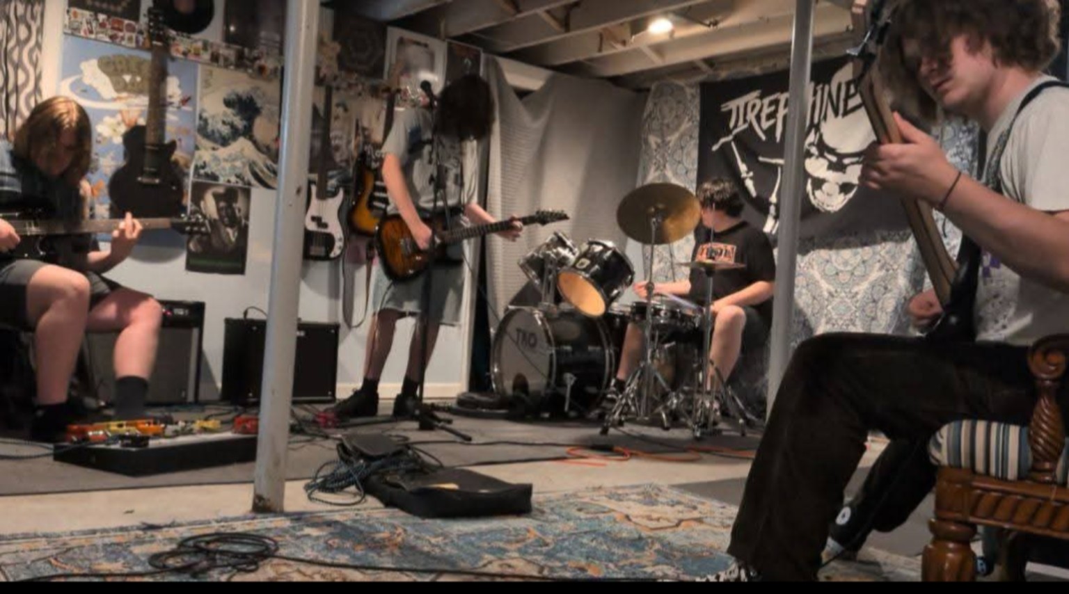 Trephine rehearsing together in their basement practice space